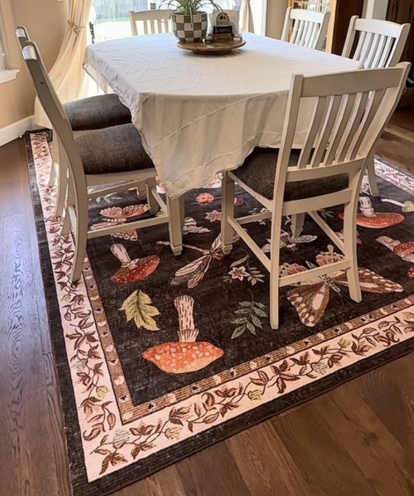 Fall dining room with a pumpkin-patterned rug, white tablecloth, and gray chairs