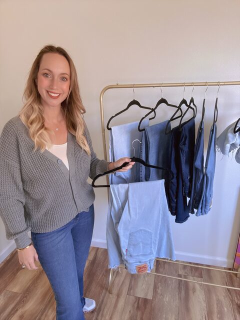 Sara styling light-wash Levi’s denim beside a clothing rack