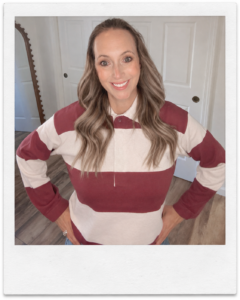 Sara wearing a mauve and cream striped rugby sweater with light-wash jeans