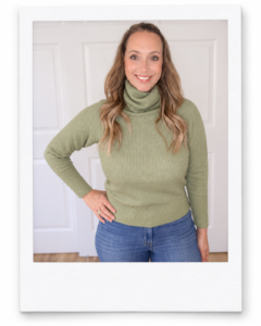Sara wearing a sage-green Quince baby alpaca-wool turtleneck with jeans.