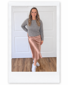 Sara wearing a gray Quince cashmere sweater with a vintage-pink silk midi skirt.